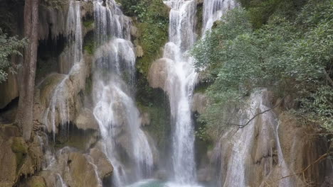 Aufsteigende-Dschungelantenne-Zeigt-Mann-Auf-Stufe-Des-Wasserfalls-Kuang-Si,-Laos