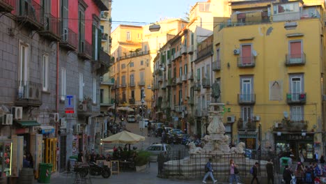 Naples,-Italy:-View-of-a-famous-fountain-on-the-Monteoliveto-square-in-the-historical-center-of-Naples,-Italy-sunset-time-with-tourists-going-around