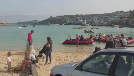 Tourist-Wait-while-People-Return-from-Speed-Boat-Trip-at-Sandy-Shore,-St-Ives-Harbour,-Cornwall,-England,-UK