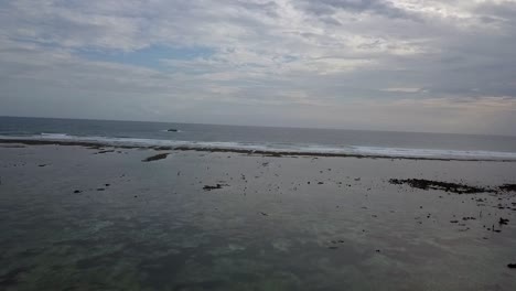 Olas-En-El-Borde-Del-Arrecife-Reflujo-Marea-Pescadores-Barco-Fantástica-Vista-Aérea-Vuelo-Volar-Hacia-Atrás-Imágenes-De-Drones-Pantai-Kuta-Lombok-Indonesia-2017