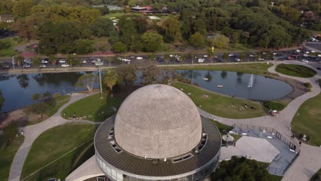 Drohnenflug-über-Das-Planetario-Gebäude-In-Buenos-Aires,-Argentinien-Mit-Der-Stark-Befahrenen-Straße-Und-Den-Seen-Im-Hintergrund