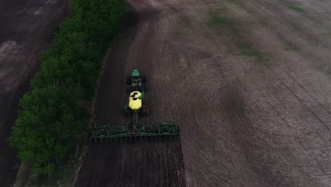 A-high-angle-shot-following-a-John-Deere-tractor-seeding-a-field