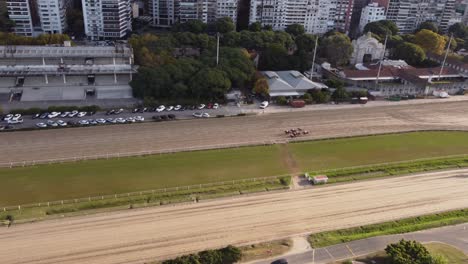 A-dynamic-aerial-footage-of-running-horses-ridden-by-jockeys-in-the-Hipódromo-Argentino-de-Palermo-horse-racing-course-located-in-Buenos-Aires,-Argentina