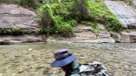 Tourist-groups-hiking-through-water-in-The-Narrows-Trail-inside-Zion-National-Park