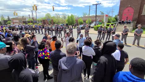Angry-crowd-mob-standing-across-a-line-of-policemen-lined-up-after-a-mass-shooting-on-the-streets-in-Buffalo