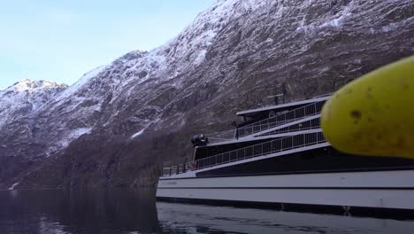 Vision-Des-Elektrischen,-Emissionsfreien-Ausflugsboots-Der-Fjorde-Daneben-In-Gudvangen,-Norwegen---Langsames-Einfahren-Mit-Anlegepoller-Im-Vordergrund-Und-Bergfjordlandschaft-Im-Hintergrund