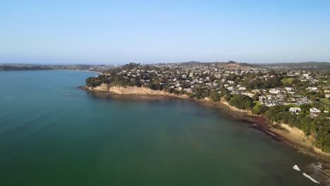 Drone-lowering-over-ocean-water-to-show-clifftop-properties
