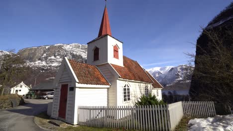 Zu-Fuß-In-Richtung-Alte-Historische-Miniatur-Stabkirche-In-Undredal-Norwegen---Sonniger-Wintertag-Mit-Blauem-Himmel-Und-Berglandschaft-Im-Hintergrund