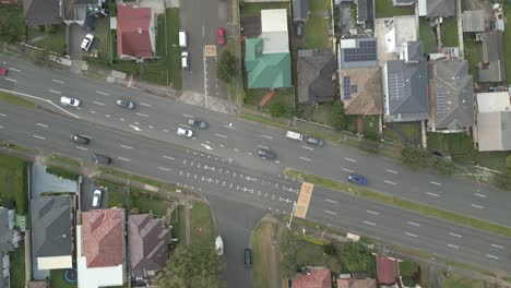 Top-down-aerial-of-cars-drive-at-cross-road-in-suburban-highway