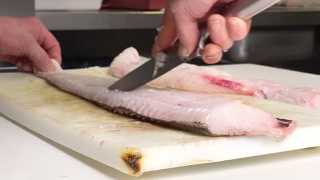 Big-hake-is-being-cut-in-fillets-before-cooking-them