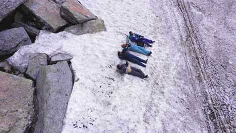 Top-shot-of-4-people-lying-down-above-the-snow-in-Manali-India