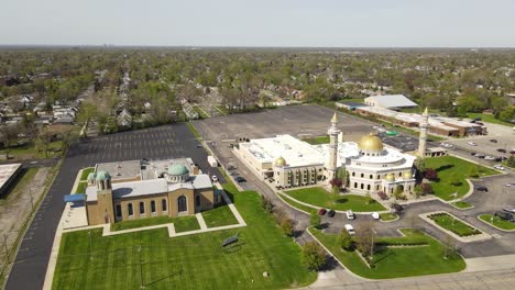 Aerial-forwarding-descending-shot-of-Islamic-Center-of-America-side-by-side-with-Christian-church,-Dearborn-Michigan