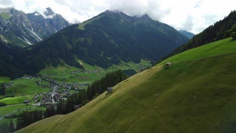Drone-aerial-view-of-meadow-with-high-mountains-in-the-background,-close-to-Vergoer---a-small-Village-in-Stubai-Valley-of-Austria