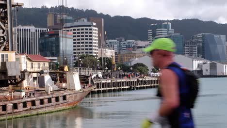 Gente-Corriendo-Y-Caminando-Por-El-Paseo-Marítimo-Del-Puerto-Con-El-Fondo-De-La-Ciudad-Durante-El-Maratón-Gazley-Volkswagen-Wellington-2022-En-Nueva-Zelanda-Aotearoa