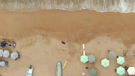 Top-down-View-Of-Parasols-At-The-Shore-With-Splashing-Waves-In-Yelapa-Beach,-Jalisco,-Mexico---aerial-drone-shot