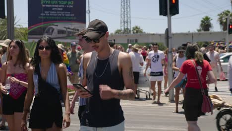 Junge-Leute,-Die-Am-10.-Juni-2022-Bei-Der-Pride-Parade-In-Tel-Aviv-Die-Straße-überqueren-Und-In-Die-Kamera-Winken