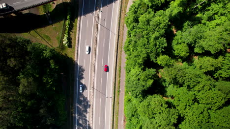 4K-Aerial-View-Of-Cars-On-Highway-Overpass-With-Green-Forest-Next-To-It