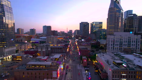 Aerial-view-towards-the-Broadway-street,-colorful-summer-evening-in-Nashville,-USA