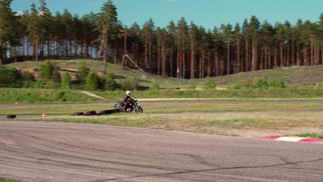Motorbiker-testing-his-skills-in-local-race-track,-slow-motion-follow-view