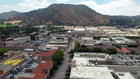 Aerial-Drone-Pull-Back-Over-Famous-Warner-Bros-Studio-Lot-Rooftops,-Burbank,-United-States