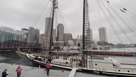 Historisches-Schiff-Im-Hafen-Von-Boston,-Skyline-Von-Boston-Im-Hintergrund-An-Einem-Wolkigen,-Bewölkten-Tag