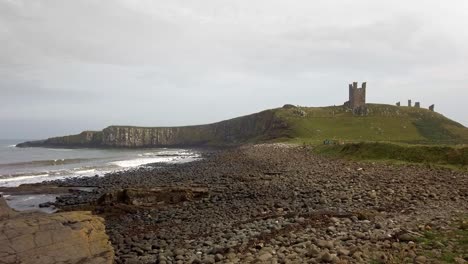 Stimmungsvolle-Küstenaufnahmen-Aus-Northumberland-Mit-Brechenden-Wellen-Und-Einer-Burg