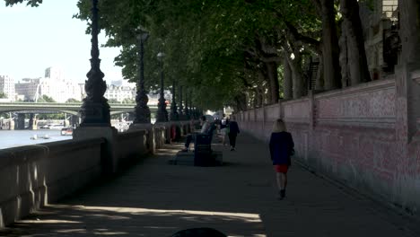 Menschen-In-Der-öffentlichkeit-Gehen-Morgens-Gemächlich-Den-Fußweg-Entlang-Mit-Der-Themse-Auf-Der-Linken-Und-Der-Nationalen-Covid-gedenkmauer-Auf-Der-Rechten-Seite,-London,-England