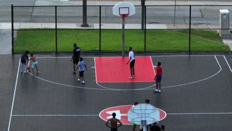 African-American-boys-and-male-teens,-men-play-basketball-in-inner-city