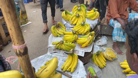 Ein-Lokaler-Alter-Mann,-Der-Bananen-Unter-Freiem-Himmel-Auf-Einem-Belebten-Straßenmarkt-Verkauft