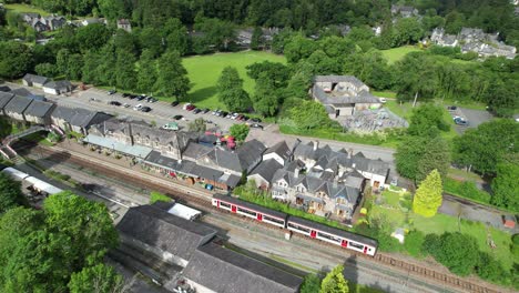 Betws-y-coed-railway-station-train-leaving-platform-north-Wales-UK-drone-aerial-view
