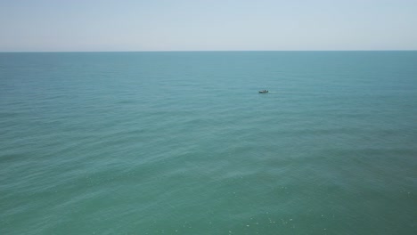 Single-small-fishing-boat-among-vast-water-empty-water