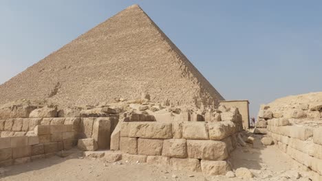 Sand-blocks-in-front-of-the-Pyramid-of-Khufu,-at-the-Giza-pyramid-complex,-in-sunny-Egypt,-Africa---tilt-view