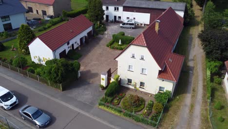Farm-vacation-camp-Buttery-soft-aerial-view-flight-fly-backwards-drone-footage
at-Countryside-village-Hainichen-in-Europe-Saxony-Anhalt,-summer-2022