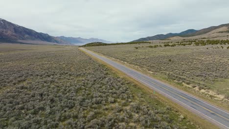 AERIAL---Truck-on-highway-next-to-Scipio-Lake,-Utah,-wide-shot-forward