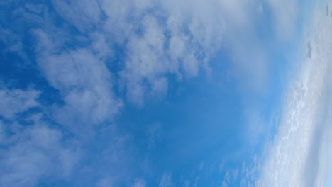 Vertical-format:-Thin-cumulus-clouds-traverse-blue-sky-in-time-lapse