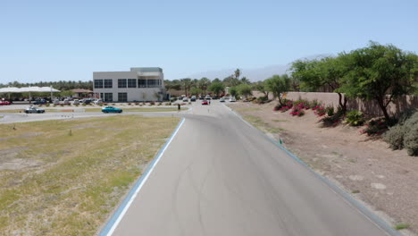 Un-Dron-Captura-Una-Toma-Aérea-De-Un-Auto-Conduciendo-Por-Una-Carretera-En-Palm-Springs,-California,-Cerca-De-Los-Ángeles.