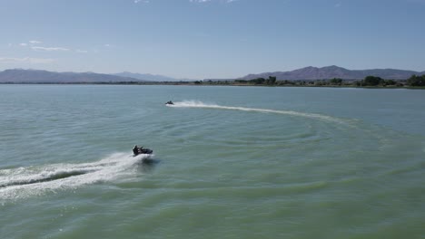 Pair-of-Two-People-Having-Fun-Riding-Jet-Ski-Sea-Doos-on-Utah-Lake,-Aerial