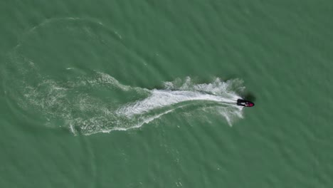 Rider-on-Sea-Doo-Jet-Ski-Speeding-on-Water-Surface-of-Lake,-Aerial-Overhead