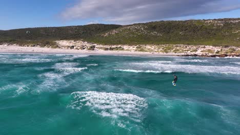 Kitesurfer-jumping-off-azure-blue-wave-doing-flip-trick-on-African-coast
