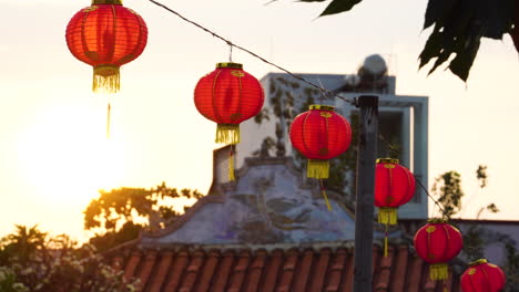 Chinese-red-paper-lantern-hanging-and-swaying-in-wind-at-sunset