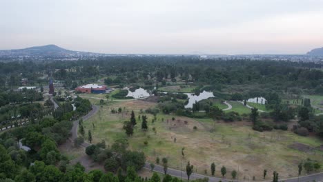 Orbital-hyperlapse-around-a-lake-with-view-of-a-highway-and-a-natural-area-in-Xochimilco,-Mexico-City