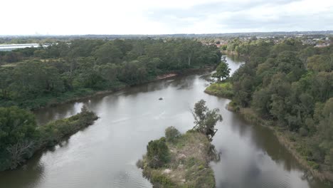 Cinematic-aerial-view-of-drone-flying-along-the-small,-narrow-and-calm-river