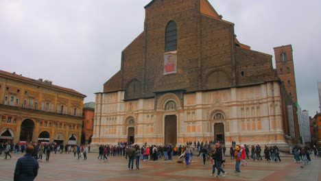 Facade-Exterior-Of-Basilica-di-San-Petronio-With-Crowded-People-On-The-Courtyard-In-Bologna,-Italy