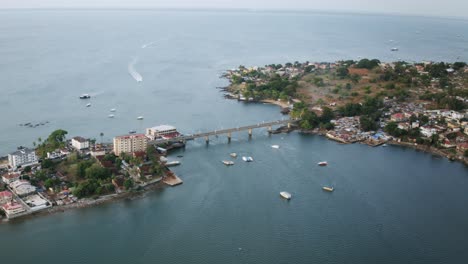 Aerial-hyperlapse-of-the-Aberdeen-Bridge-in-Freetown,-Sierra-Leone-with-boats-driving-around