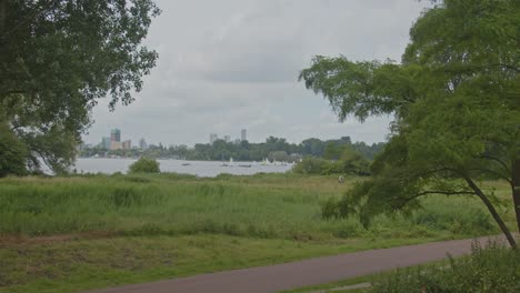 Rotterdam-skyline-seen-from-Kralingse-Bos-in-the-Netherlands-with-a-bicycle-path-in-the-foreground