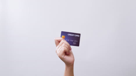 Woman's-hand-shows-a-credit-card-ready-for-shopping-online-in-white-studio-background-with-copy-space
