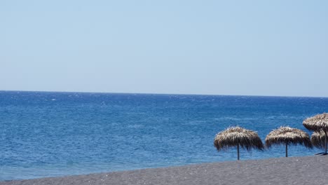 Cabañas-De-Sol-En-La-Playa-Clara-En-Las-Islas-De-Santorini,-Grecia