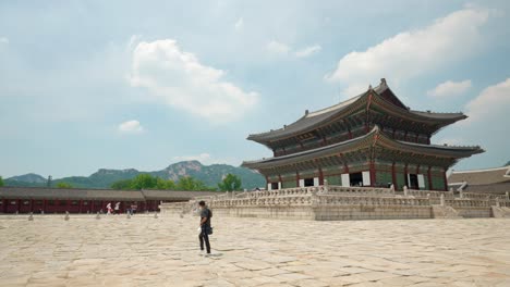 Mann-Tourist-Filmt-Hyperlapse-Video,-Das-An-Einem-Sonnigen-Tag-Durch-Den-Gyeongbokgung-Palast-Geht