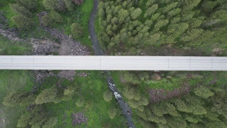 Drone-looks-down-from-birds-eye-view-towards-a-bridge