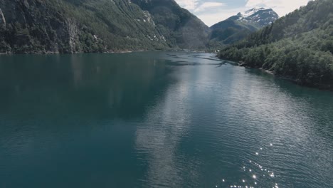 Blue-lake-water-of-Tafjord-area-in-Norway,-aerial-FPV-drone-view